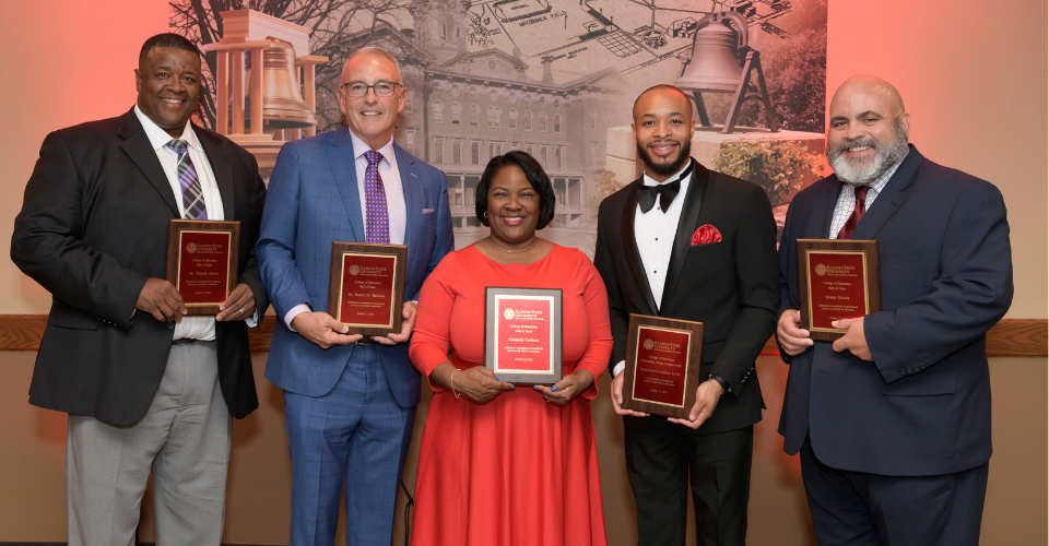 2023 Alumni Award recipients pose together with their award plaques.